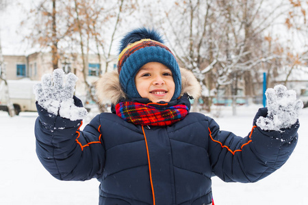 快乐的男孩在冬天的雪地里散步