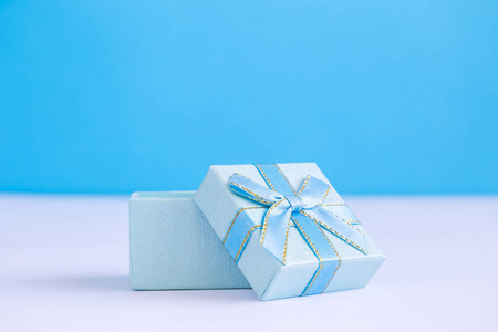 桌子上的小蓝色礼品盒最小圣诞创意概念。 复制的空间。