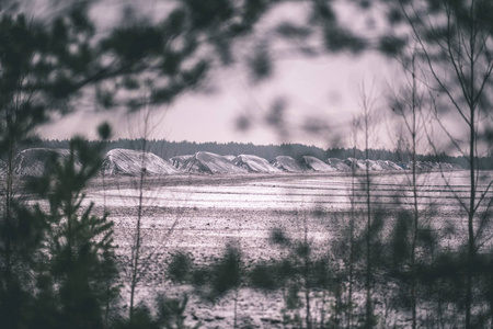 雪覆盖田野的乡村景色在黑暗的多云天空下