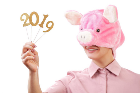 女孩在一只粉红色的猪的形象中微笑着展示2019年的数字。新年。 在白色背景上孤立的肖像