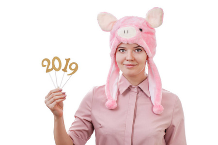 年轻女孩穿着猪装，手里拿着2019年的数字，期待着新年的到来