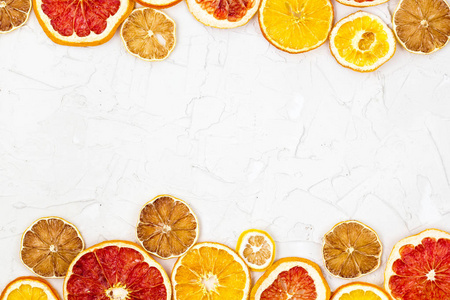 白色背景下各种柑橘类水果干片的边缘。 许多带有咖啡空间的橙色柠檬葡萄柚