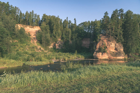 拉脱维亚阿马塔河的水流，夏季有砂岩悬崖和树林