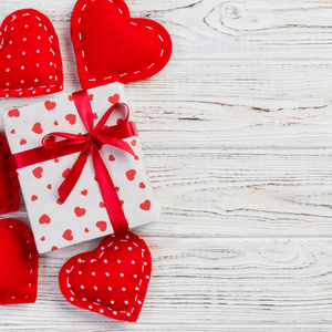 情人节或其他节日手工礼物纸与红心和礼品盒在假日包装。 赠送礼品盒在白色木桌上的顶部视图与复制空间空空间的设计。