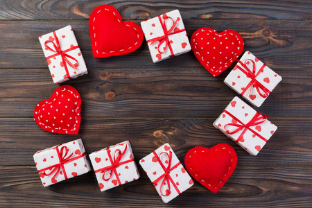 情人节或其他节日手工礼物纸与红心和礼品盒在假日包装。 礼物盒在深色木桌上的顶部视图与复制空间空空间的设计。