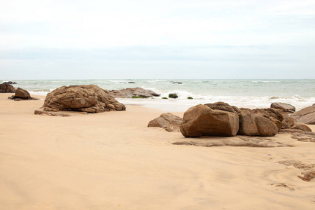 沙滩上的大型花岗岩石头背景图像复制文本