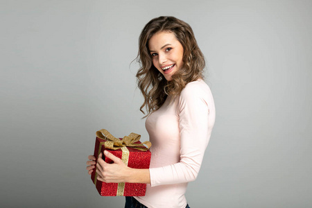 年轻而快乐的女人准备好了，手里拿着圣诞礼物