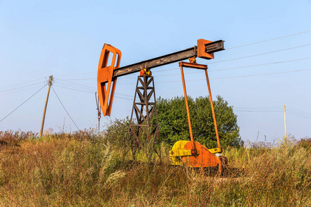 一个小型的私人石油井架在现场泵油。 旧手工油钻机在创意工业设计的背景下。 非法开发矿物。 保加利亚Tulenovo2016