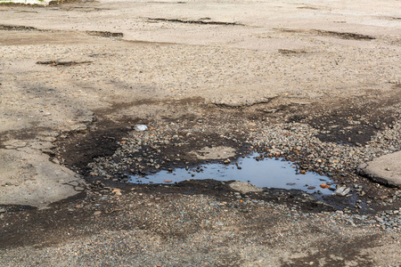 路面坑洞的裂缝. 低质量修补后局部沥青道路状况极差照片