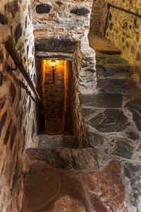 保加利亚的一座中世纪城堡古基督教修道院塔中的一个狭窄的石阶。 神秘阴森的隧道，有石墙