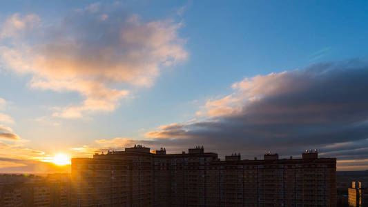 城市上空冉冉升起的太阳照片