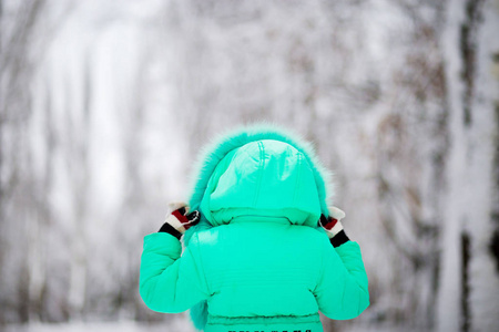 有趣的小女孩在美丽的冬季公园里玩雪