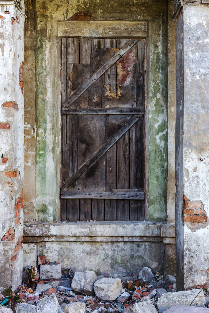 旧木门风化裂缝油漆所以旧木门在一个古老的石头房子的墙上在奥黛莎
