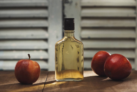 木制背景的天然苹果汁瓶和杯