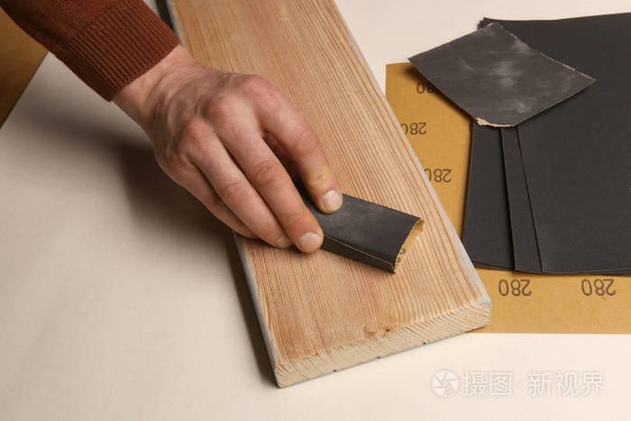 人手平滑木板使用砂纸打磨和抛光木落叶松木板