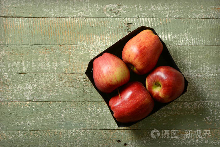 绿色木桌上的盒子里有四个红苹果照片-正版商用图片15rt57-摄图新视界
