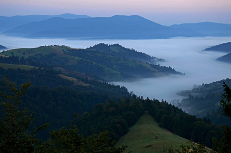 晨雾在喀尔巴阡山脉的背景上，山峰覆盖着树木