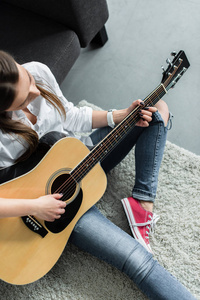 客厅里女孩坐着弹吉他的局部景观