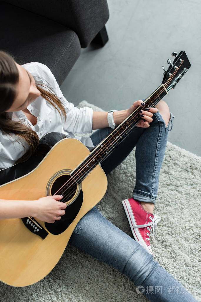 客厅里女孩坐着弹吉他的局部景观
