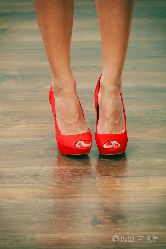 女性时尚。女性腿上穿着紧身红色高跟鞋