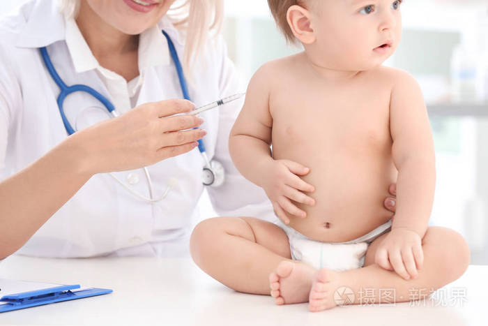 女医生在诊所给男婴接种疫苗