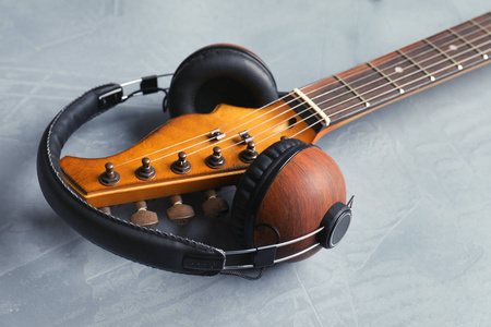 现代电动吉他带耳机彩色背景特写镜头