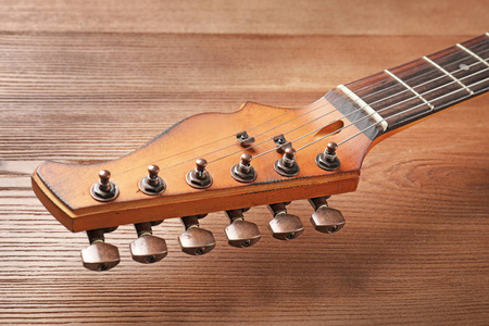 现代电动吉他在木制背景特写视图。 乐器