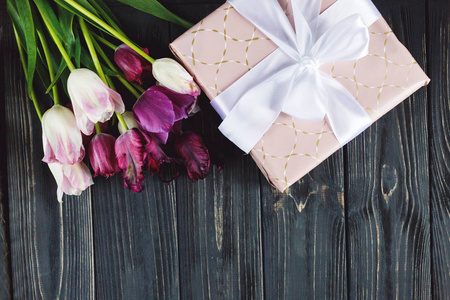 五颜六色，美丽的粉红色紫罗兰郁金香和礼品盒在灰色的木桌上。 情人节春天的背景。 花卉模拟。 与共空间。 幸福的日子浪漫的日子新鲜