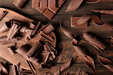 木制背景上有巧克力卷曲的平躺构图