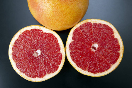 在黑暗的背景下切柑橘类水果葡萄柚