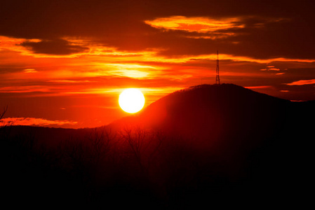 红日落日的天空和地平线上的山影