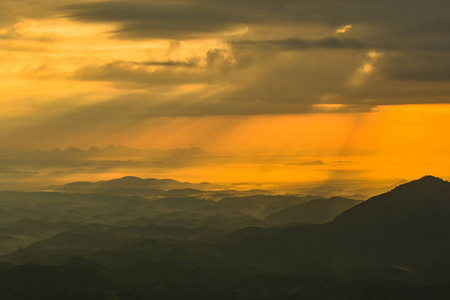 太阳在早晨升起新的一天山上美丽的风景日出，阳光照耀在云黄的天空，美丽的山脉背景