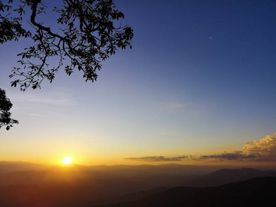 美丽的自然日落或日出的天空在田野上。 傍晚乡村景观概念。 地平线橙色天空在山景背景上戏剧性