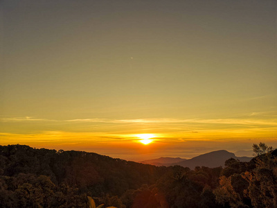 美丽的自然日落或日出的天空在田野上。 傍晚乡村景观概念。 地平线橙色天空在山景背景上戏剧性