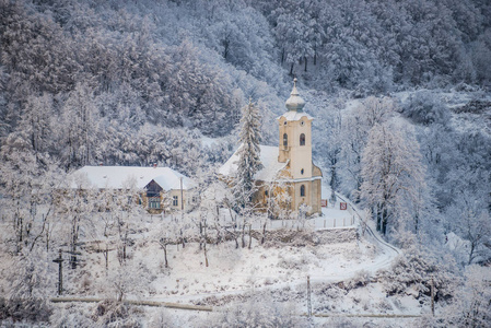 雪覆盖的树木和景观与教堂在阿尔卑斯山