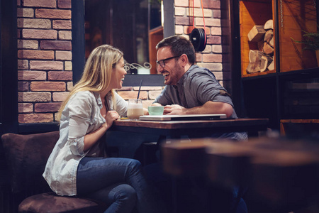 爱的夫妇坐在咖啡馆里享受咖啡和谈话。