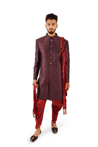 优雅的男人穿着明亮的印度传统服装，看着相机，在白色背景上摆出孤立的姿势