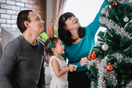 准备圣诞树的幸福家庭的肖像