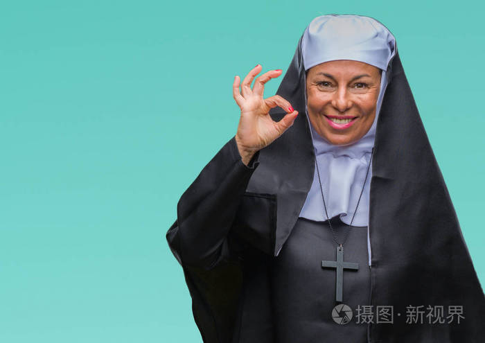 中年高级基督教修女妇女在孤立的背景下微笑积极做好手和手指的ok标志