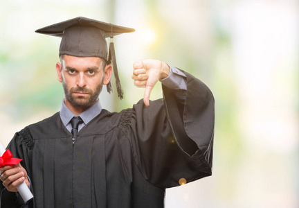 年轻的英俊的毕业的在孤立的背景下持有学位的愤怒的消极的不喜欢的竖起大拇指的拒绝观念