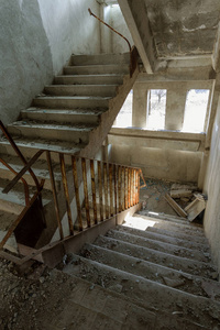 商业中心未完成的行政大楼废墟内部旧的混凝土石楼梯。 废弃厂房内部破旧楼梯