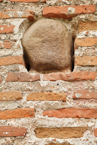 旧毁砖墙的纹理背景与石头近景。 在保存被破坏的墙壁元素的同时恢复，以显示墙壁的组成