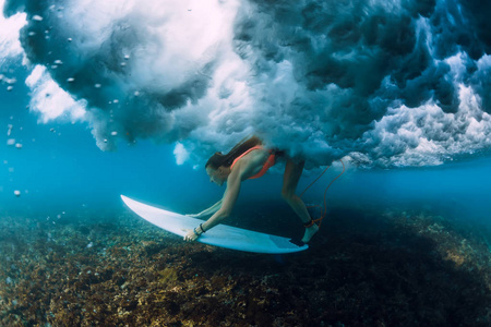 吸引人的冲浪女人潜入碰撞桶波下。
