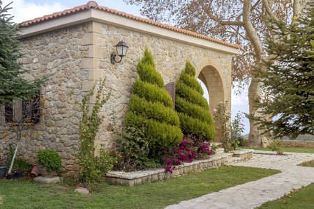 在一个秋天的阳光明媚的日子里，山上一座石头整洁舒适的乡村别墅希腊佩罗普内塞近在咫尺。