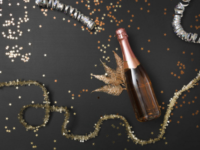 新年背景，配有一瓶香槟和黑色黑板上的圣诞装饰