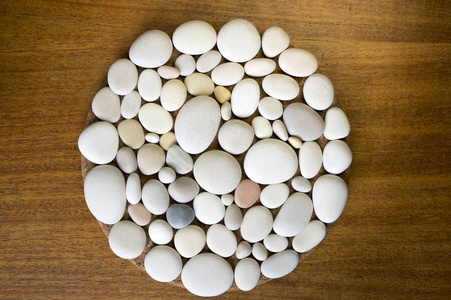 黑色木制背景上的魔法石圆形,由石头制成的浅卵石照片