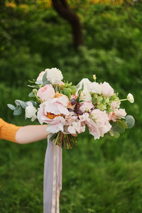 s bouquet. Flower woman holds in her hand a beautiful wedding bo