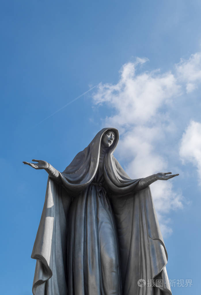 圣母玛利亚雕像青铜蓝天背景白云张开双臂