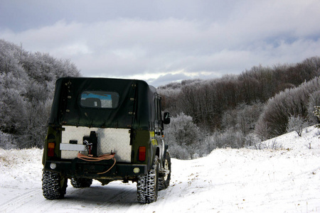 冬季森林中的4x4。 在白雪皑皑的冬天森林里在大自然中漫步。 吉普车穿过白雪皑皑的冬林。