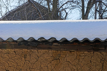 棕色的墙，屋顶上有石板，有雪堆